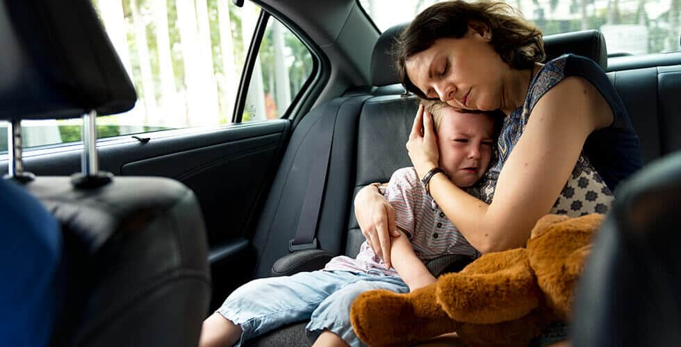 mãe consolando a filha dentro do carro contribuindo para o desenvolvimento emocional infantil