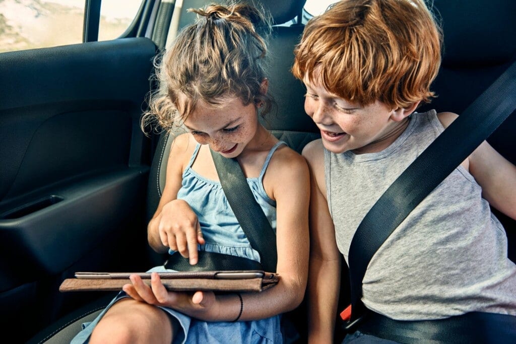 Imagem de duas crianças olhando a tela de um tablet