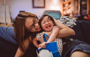 fases do desenvolvimento infantil: mãe oriental com seu filho sorrindo ao brincar