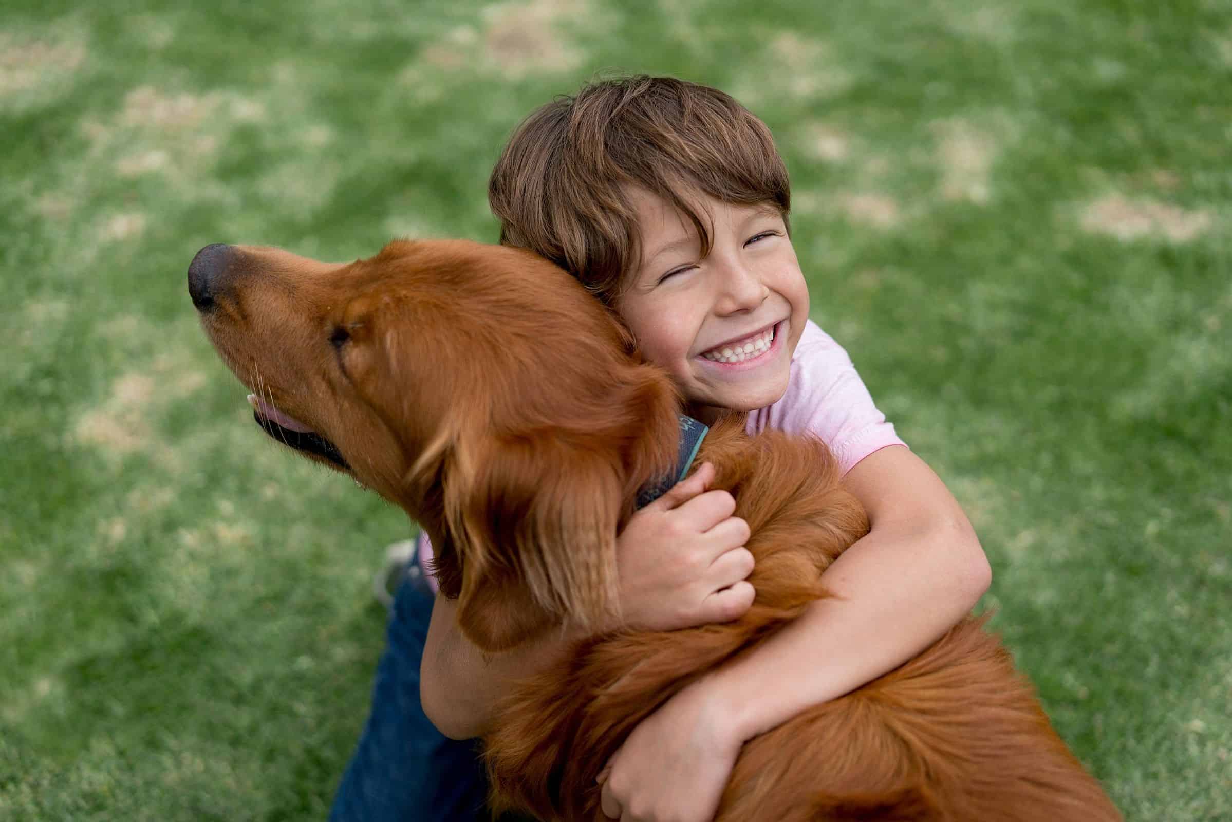 Imagem de uma criança abraçando um cachorro