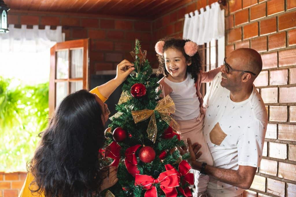 brincadeiras de natal|brincadeiras de natal: família comemorando o Natal em casa com lareira no fundo|brincadeiras de natal|brincadeiras de natal