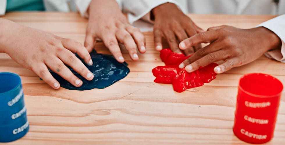 Imagem de dois pares de mãos aprendendo como fazer slime.