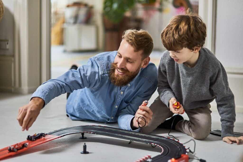 pai tentando construir uma família feliz brincando de carrinho com seu filho 