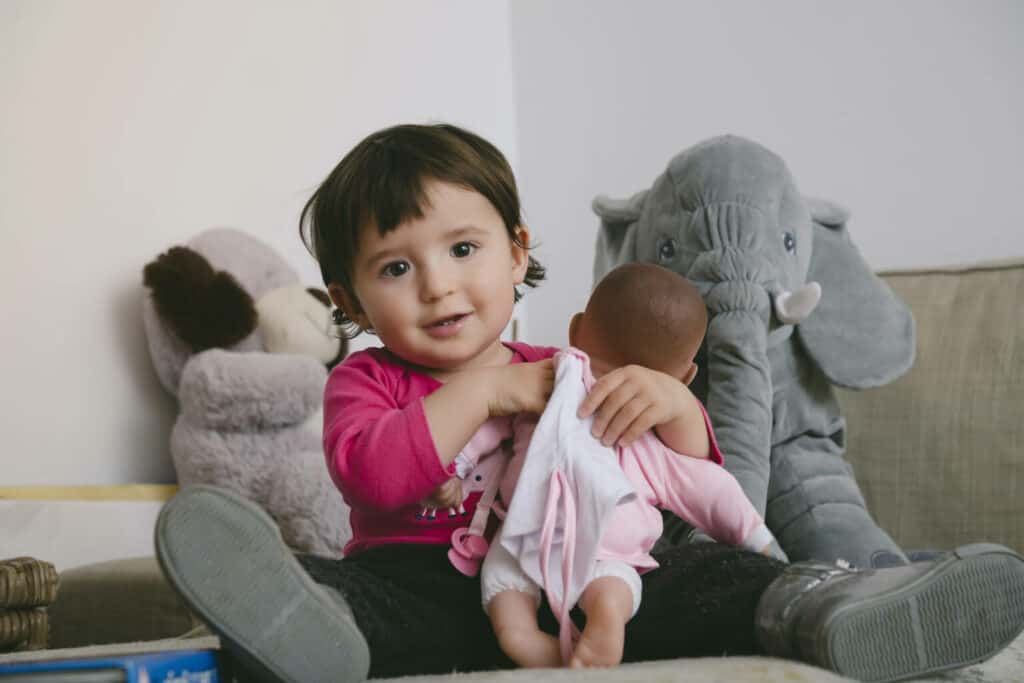 Imagem de uma criança abraçando uma boneca.