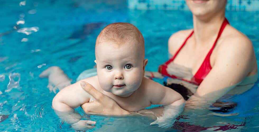 mãe descobrindo como ensinar um bebe a nadar dentro da piscina