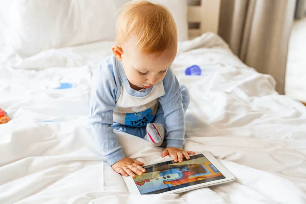 Imagem de um bebê olhando um desenho na tela de um tablet