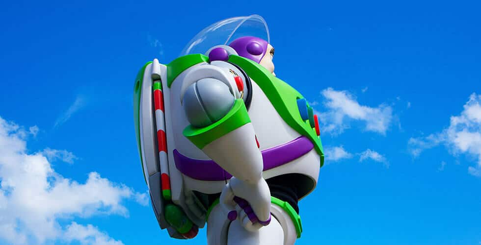 Imagem do personagem Buzz Lightyear em frente a um céu azul com nuvens brancas