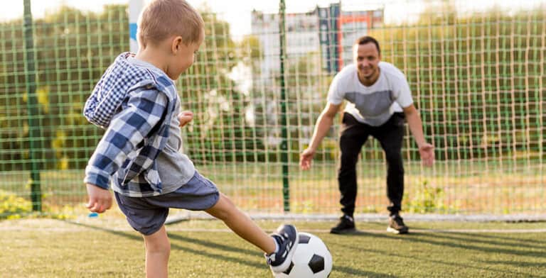 pai e filho jogando bola em quadra representando os jogos para pai e filho