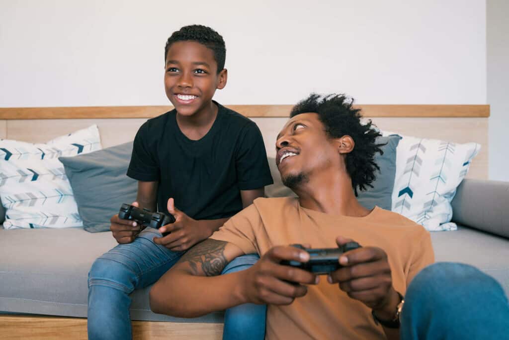 Imagem de um homem e um menino jogando videogames