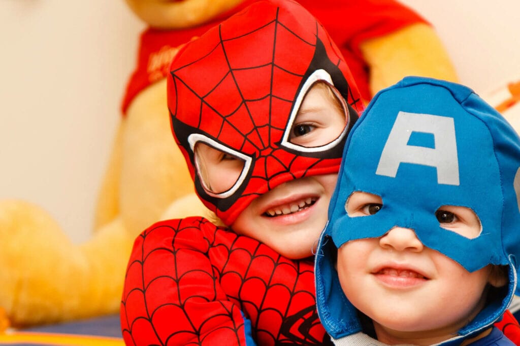 Imagem de duas crianças fantasiadas de Capitão América e Homem-Aranha