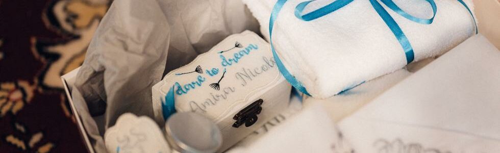 presente embalado com papel branco e laço azul representando presente para recém-nascido
