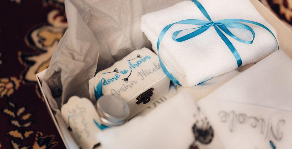 presente embalado com papel branco e laço azul representando presente para recém-nascido