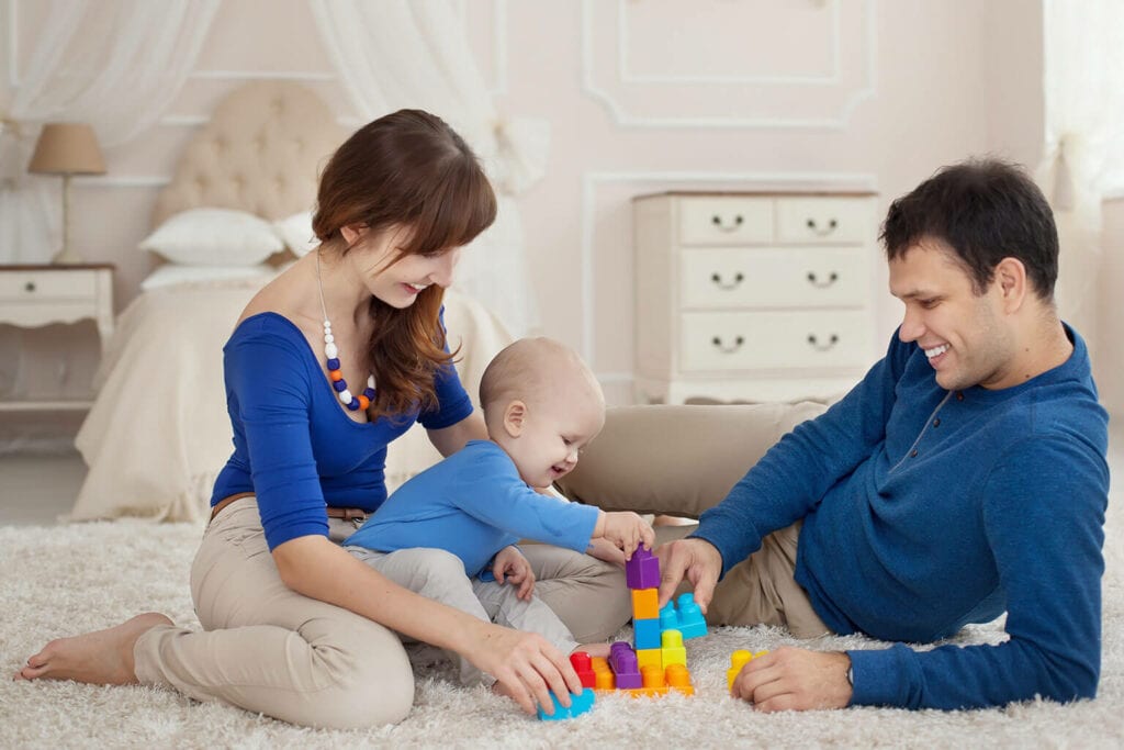 pai, mãe e bebê se divertindo com brinquedos interativos