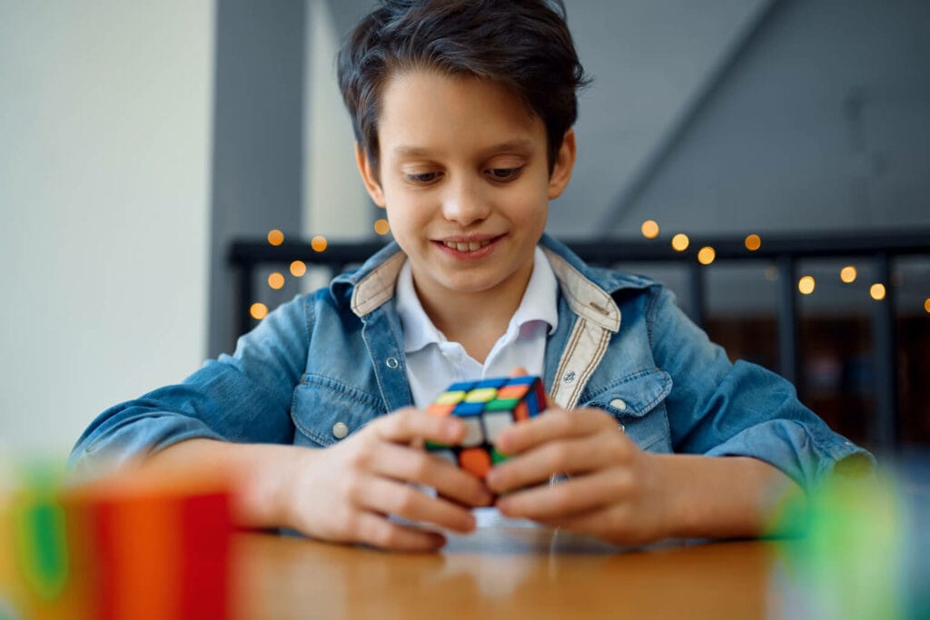 menino brincando representando como resolver um cubo mágico