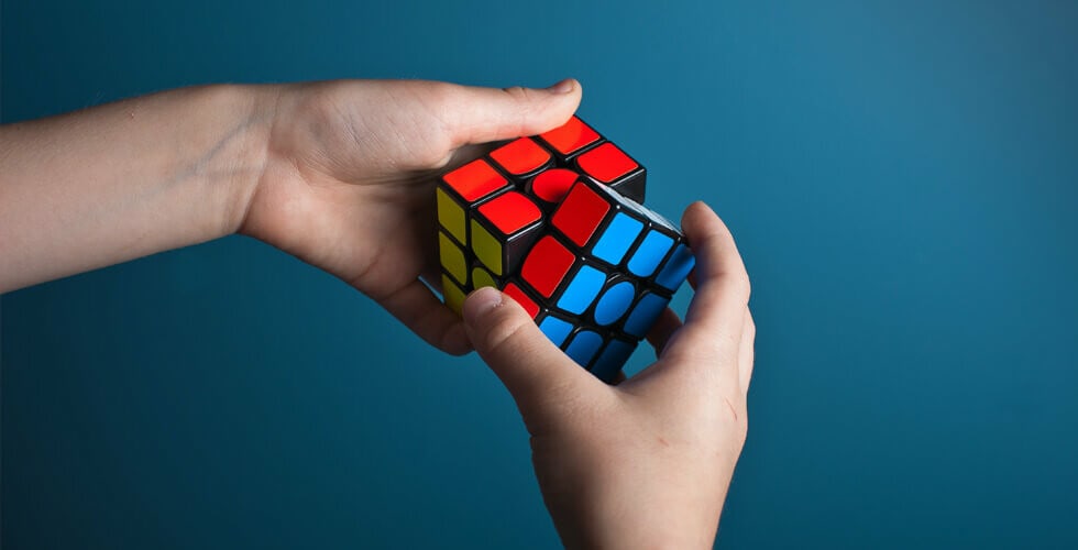 imagem de pessoa manuseando brinquedo representando como resolver um cubo mágico