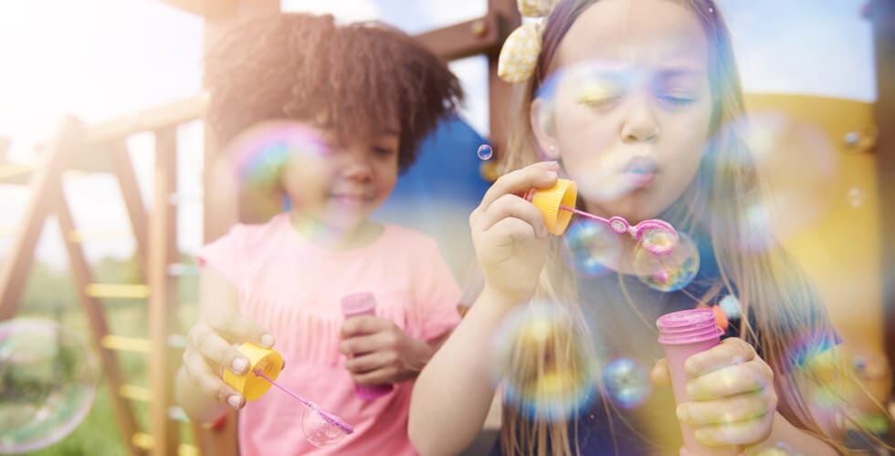 crianças brincando com bolhas de sabão nas férias de verão