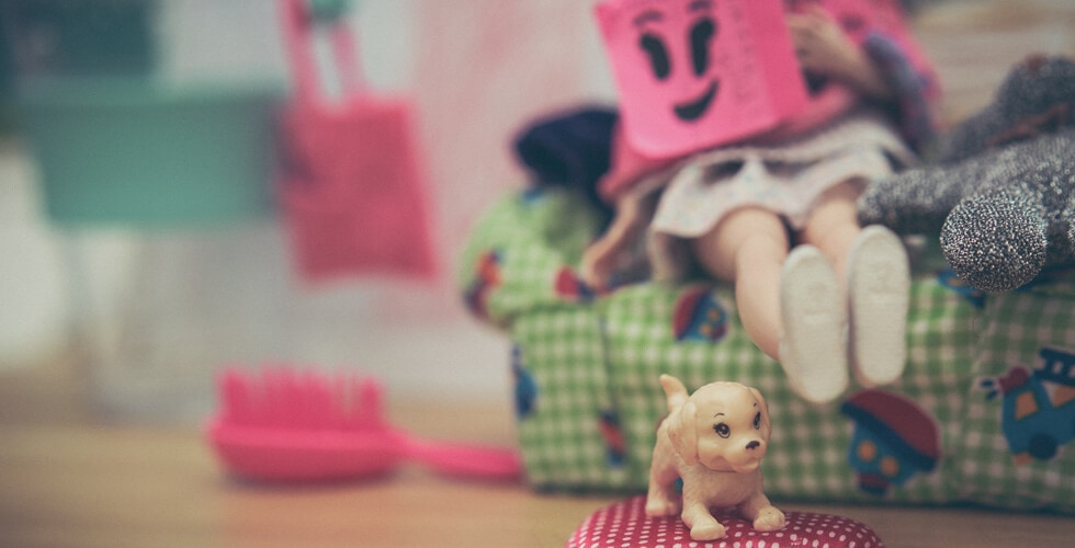 Imagem de uma boneca Barbie ao lado de um cachorrinho