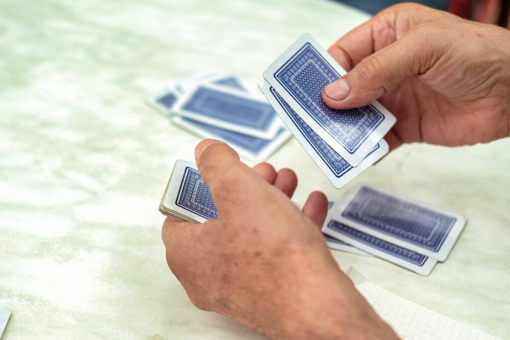 pessoa distribuindo cartas durante um dos jogos com baralho
