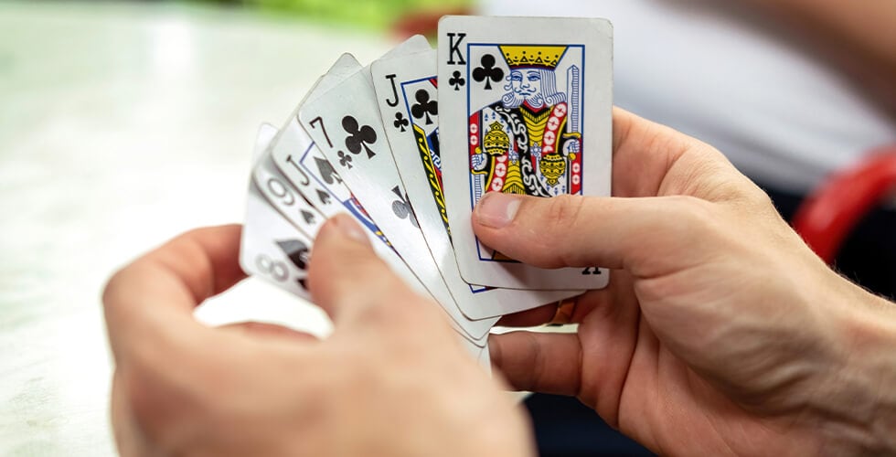pessoa segurando cartas durante um dos jogos com baralho