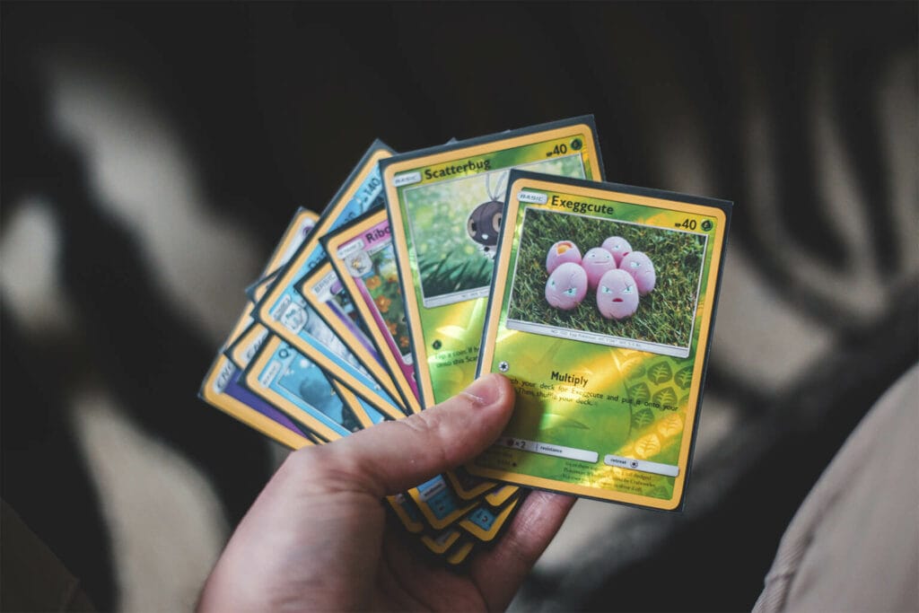 Imagem de uma pessoa segurando cartas de Pokémon 