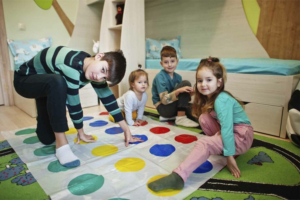 Imagem de crianças brincando com o jogo Twister