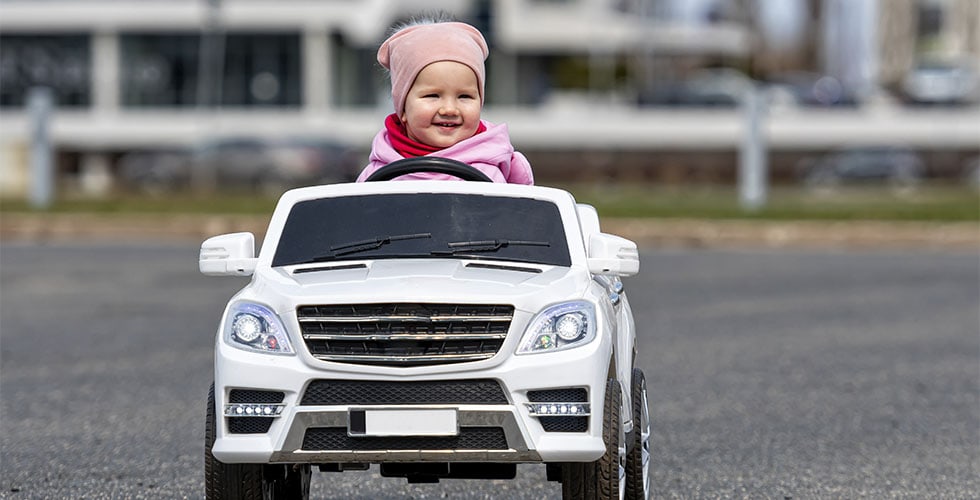bebê andando em mini-veículo representando qual é o melhor carrinho elétrico infantil