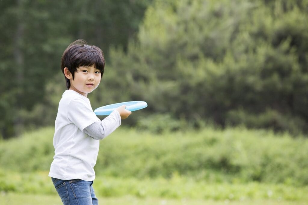 Imagem de uma criança jogando frisbee
