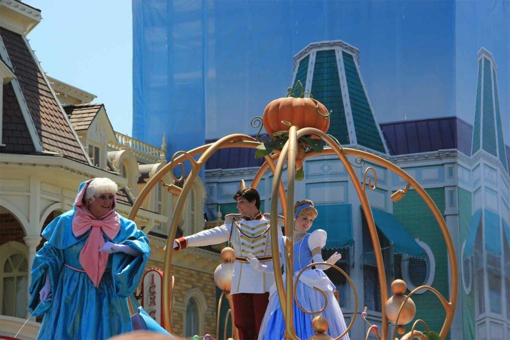 imagem da cinderal, fada madrinha e principe encantado em cima de carro alegorico representando os príncipes da Disney