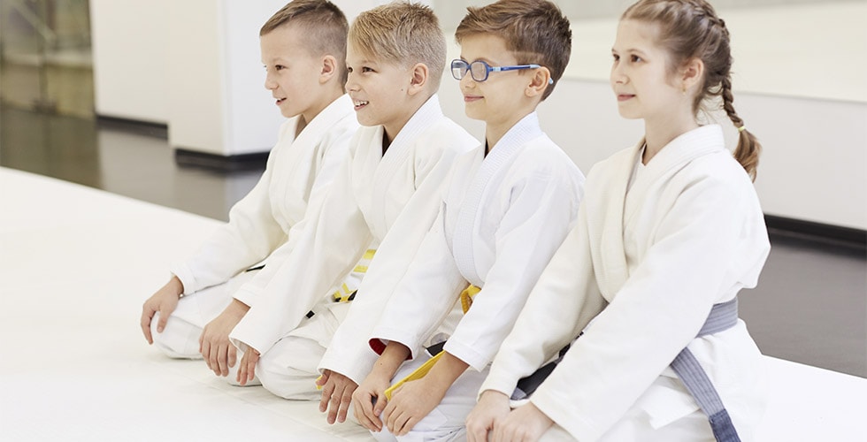 Imagem de crianças usando roupas para prática de artes marciais
