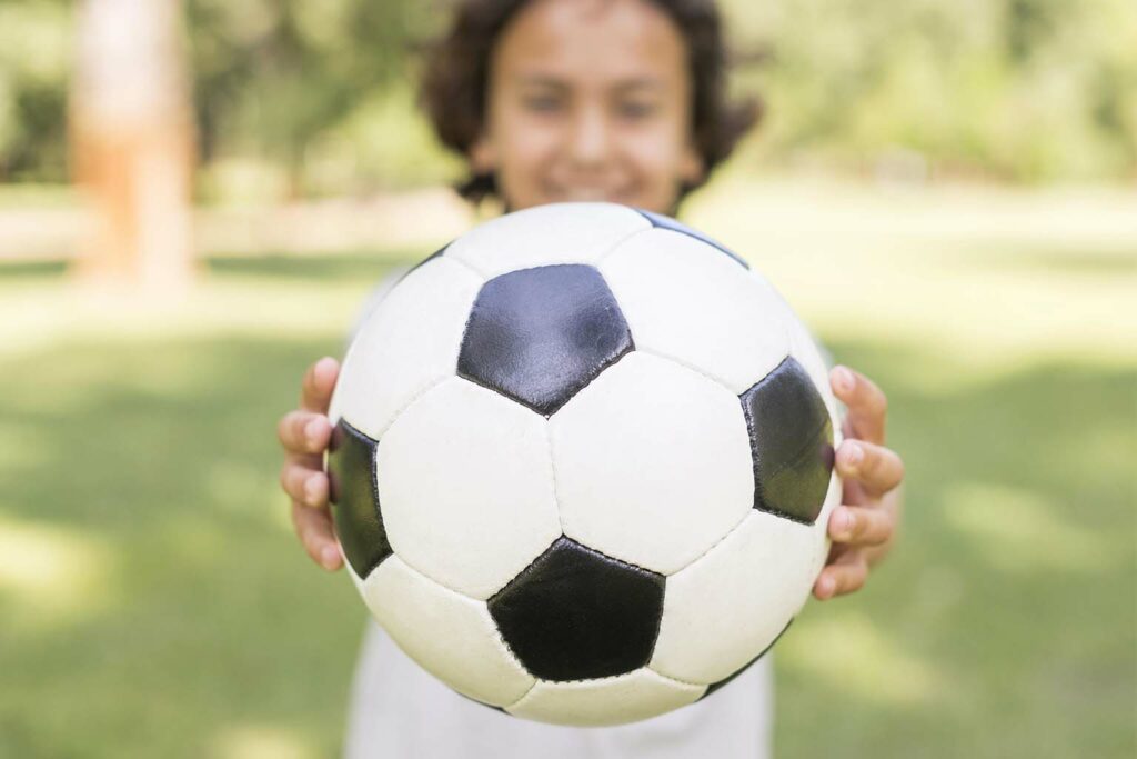 Imagem de uma criança segurando uma bola