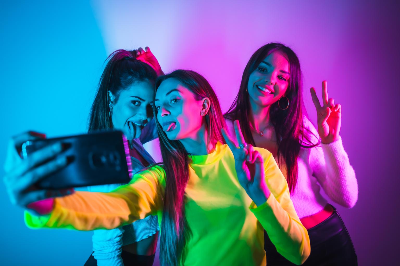 meninas posando para foto com luz neon representando temas superdiferentes para festa de quinze anos
