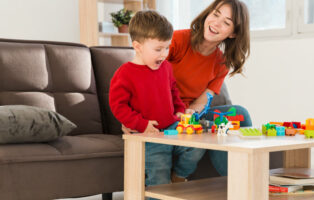 mãe e filho sentados em frente a mesa com blocos de montar representando como montar LEGO