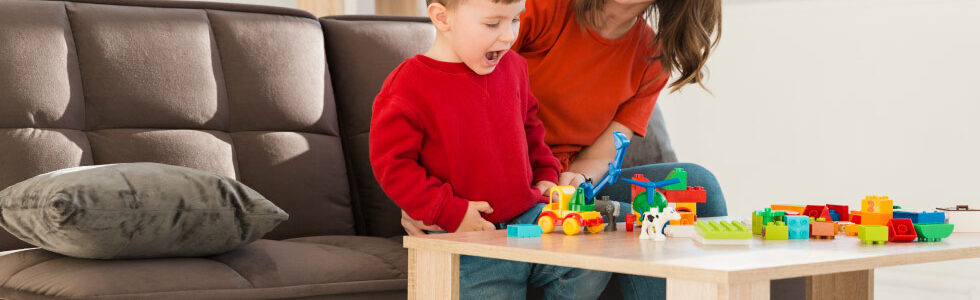 mãe e filho sentados em frente a mesa com blocos de montar representando como montar LEGO