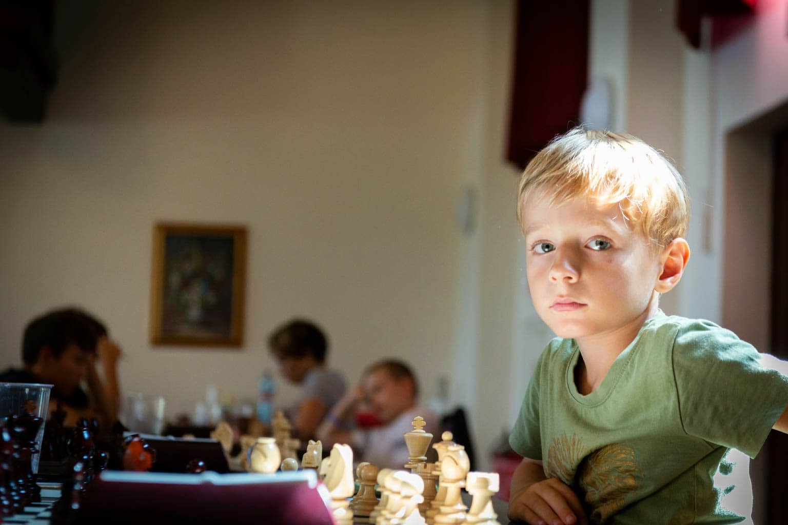 criança sentada em frente ao tabuleiro representando a história do xadrez